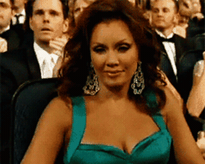 Woman In Teal Dress Sitting In Crowd GIF