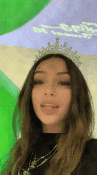 Woman In Tiara At Green Wall GIF