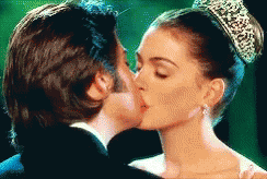 Woman In Tiara Kissing Man In Tuxedo GIF