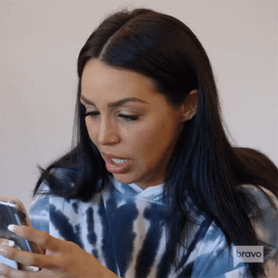 Woman In Tie Dye Hoodie Looking At Phone GIF