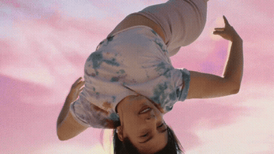Woman In Tie Dye Shirt Doing Handstand GIF