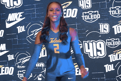 Woman In Toledo Jersey In Front Of Nike And Toledo Logos GIF