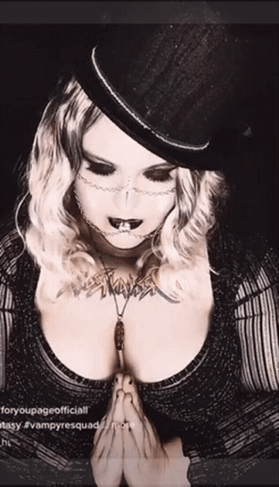 Woman In Top Hat And Necklace Praying GIF