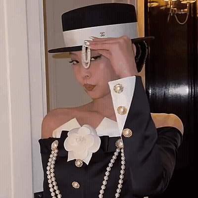 Woman In Top Hat And Pearls Adjusting Necklace GIF