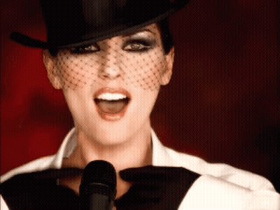 Woman In Top Hat And Veil Singing Into Microphone GIF