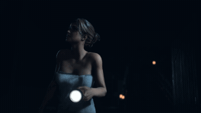 Woman in Towel Holding Flashlight in Dark