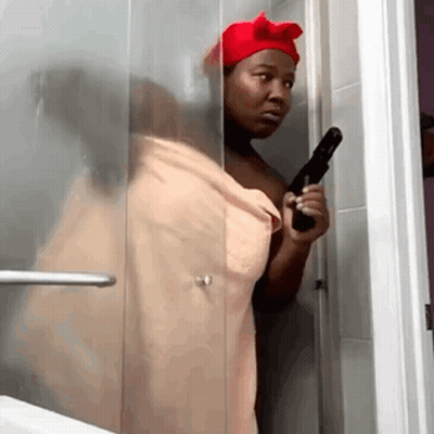 Woman In Towel Holding Gun In Shower GIF