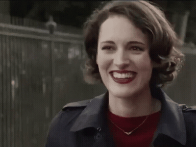 Woman In Trench Coat And Red Sweater Smiling GIF