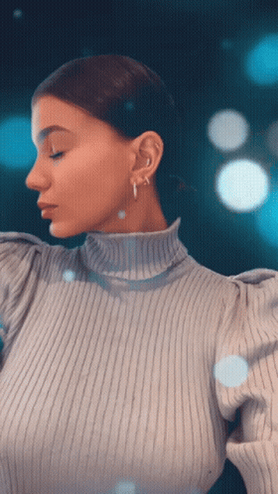 Woman In Turtleneck And Hoop Earrings Looking Down GIF