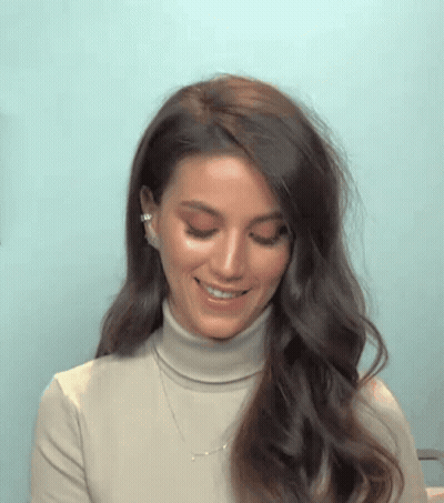 Woman In Turtleneck Smiling With Necklace GIF