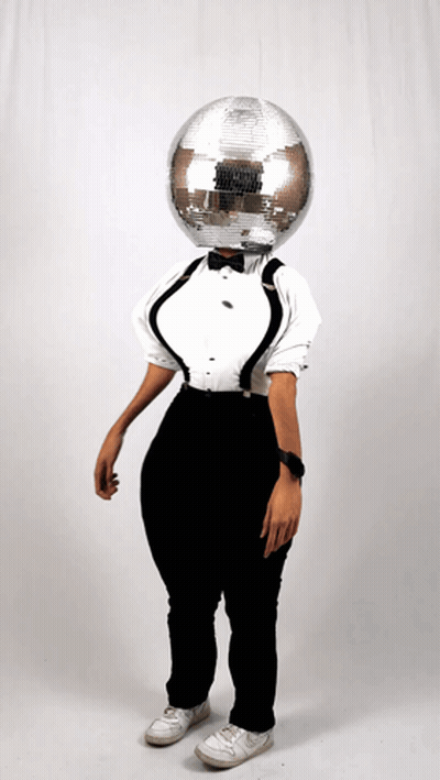 Woman In Tuxedo And Suspenders With Disco Ball On Head GIF