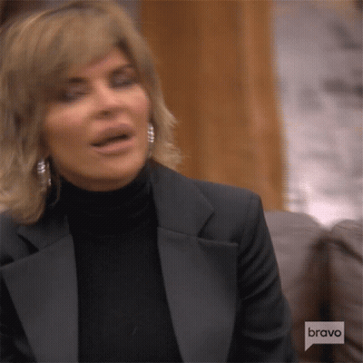 Woman In Tuxedo And Turtleneck Sitting On Couch GIF