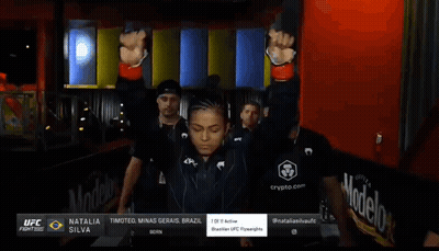 Woman In UFC Uniform Walking With Men GIF