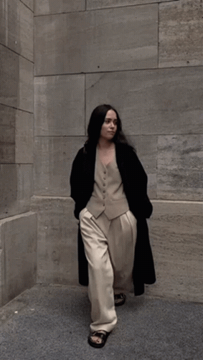 Woman In Vest And Pants Walking On Sidewalk GIF