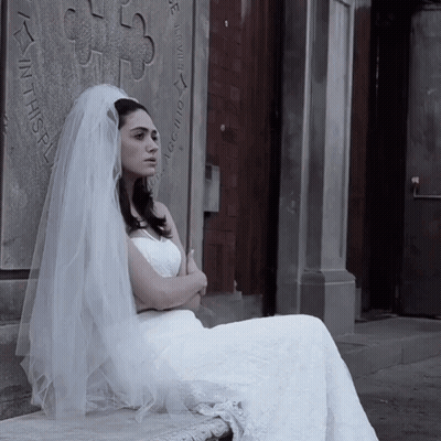 Woman In Wedding Dress Sitting In Front Of Wall Saying In This GIF