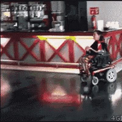 Woman In Wheelchair Riding Scooter In Restaurant GIF