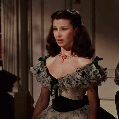 Woman In White And Green Dress With Ruffles And Necklace GIF