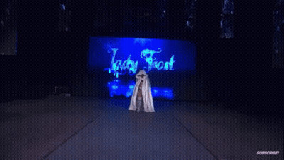 Woman In White Cape Standing Before Ice Frost Sign GIF