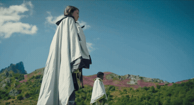 Woman In White Cape Standing In Field GIF