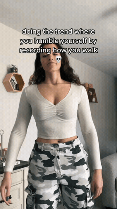 Woman In White Crop Top And Camo Pants Doing Humble Walk Trend GIF