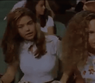 Woman In White Crop Top Sitting In Crowd With Eyes Closed GIF