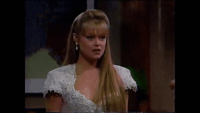 Woman In White Dress And Earrings Sitting At Table GIF