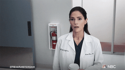Woman In White Dress And Earrings Sitting At Table GIF