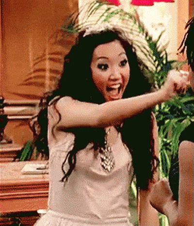 Woman In White Dress And Tiara Pointing At Another Woman GIF