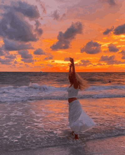 Woman In White Dress Arms Up On Beach GIF