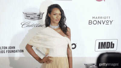 Woman In White Dress By Cadillac And Marriott Bonvoy Sign GIF