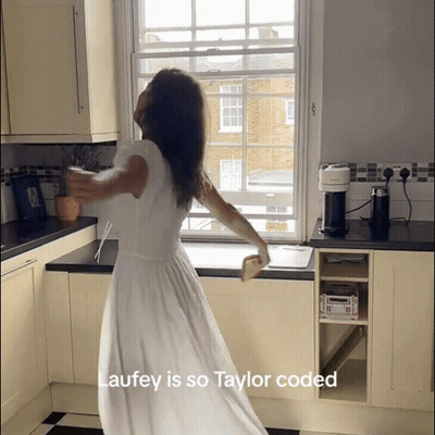 Woman In White Dress Dancing In Kitchen Laufey Is So Taylor Coded GIF