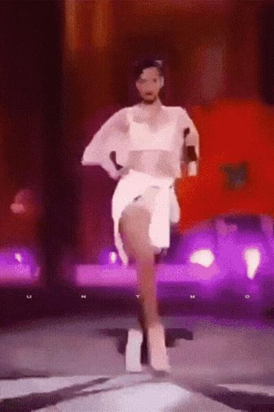 Woman In White Dress Dancing On Stage With Purple Lights GIF