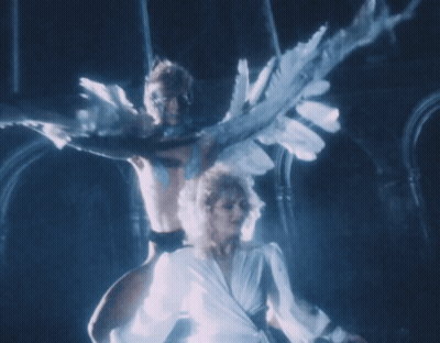 Woman In White Dress Dancing With Man With Wings GIF