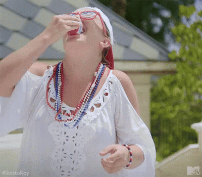 Woman In White Dress Drinking From Can With Red White Blue Beads GIF