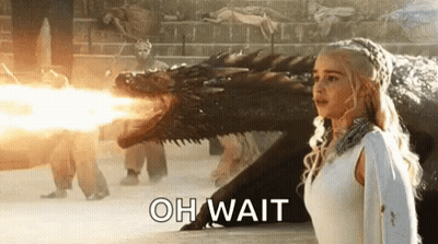 Woman In White Dress Facing Fire-Breathing Dragon GIF