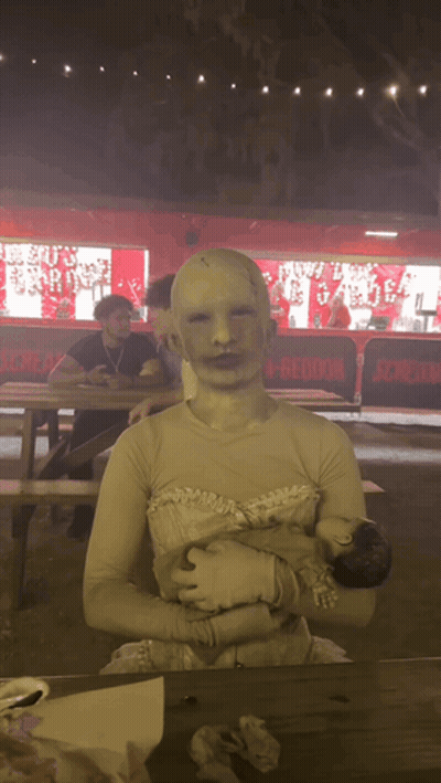 Woman In White Dress Holding Baby Beside Scream Sign GIF
