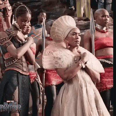 Woman In White Dress Holding Fan With Spear Holders GIF