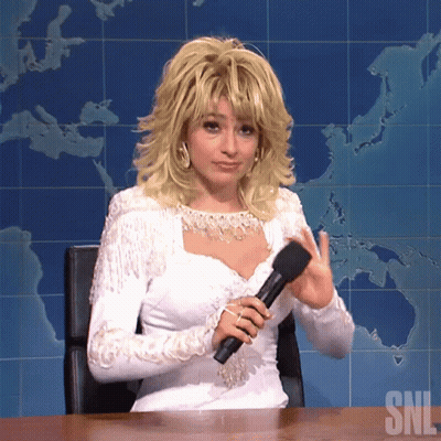 Woman In White Dress Holding Microphone In Front Of SNL Map GIF