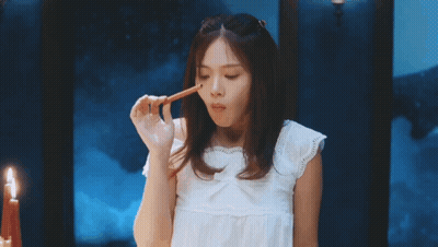 Woman In White Dress Holding Pencil To Mouth GIF