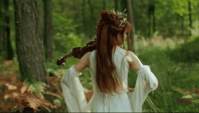 Woman In White Dress Holding Violin In Forest GIF