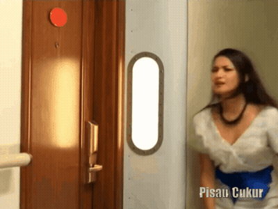 Woman In White Dress In Front Of Pisau Ukur Door GIF