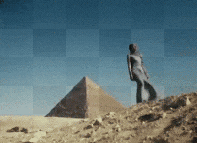 Woman In White Dress In Front Of Pyramid GIF