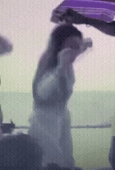 Woman In White Dress Next To Man In Purple Jacket GIF
