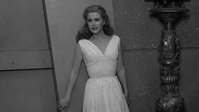Woman In White Dress Next To Pole Black And White GIF