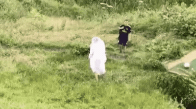 Woman In White Dress Running Through Grassy Field GIF