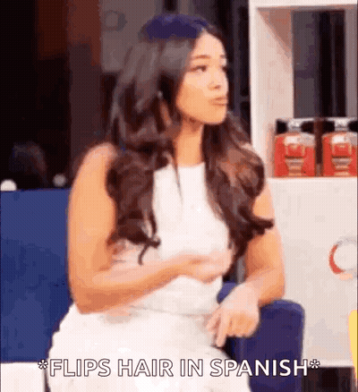 Woman In White Dress Saying Flips Hair In Spanish GIF