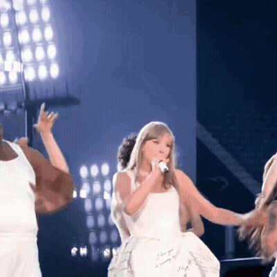 Woman In White Dress Singing Into Microphone GIF