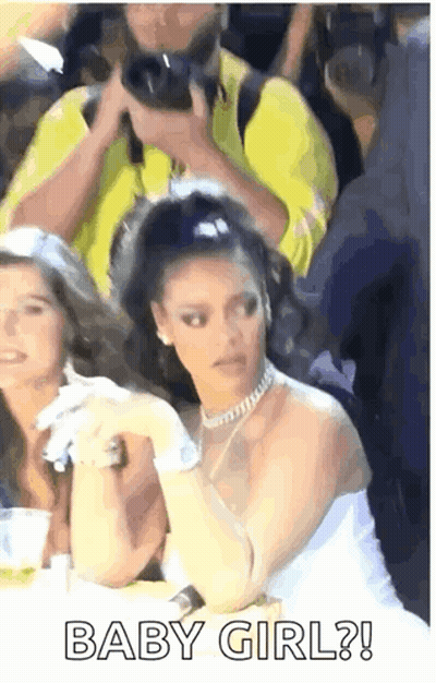 Woman In White Dress Sitting Among Crowd GIF