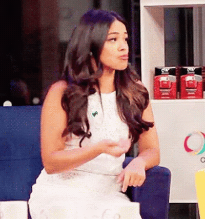 Woman In White Dress Sitting In Front Of Olay Shelf GIF
