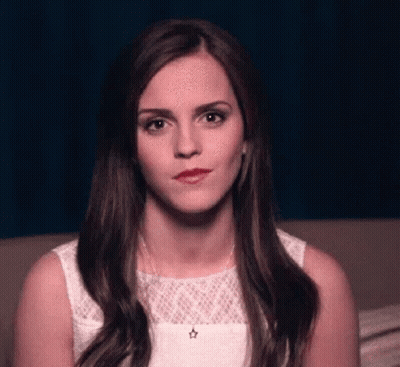 Woman In White Dress Sitting On Couch Looking At Camera GIF